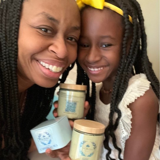GloZell and Ozell posing with two Sea The Crown body butters and a Sea The Crown Massage Candle